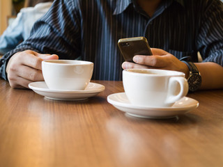 An asian man looking  at smart phone in the coffee shop