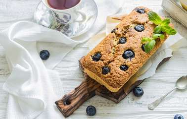 Banana pie with blueberries on a wite wooden table