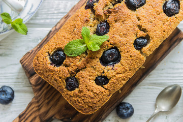 Banana pie with blueberries on a wite wooden table