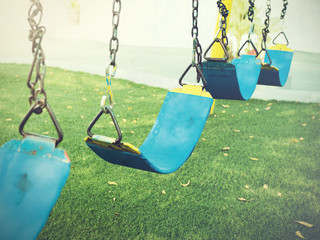 Swing playground in the green grass park