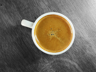 Cup of hot espresso coffee on wood table