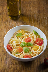 Delicious paste and olive oil bottle on wooden background