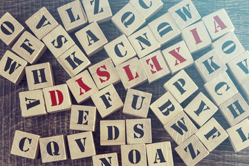 Dyslexia word formed with wooden blocks. Reading difficulties concept - obrazy, fototapety, plakaty