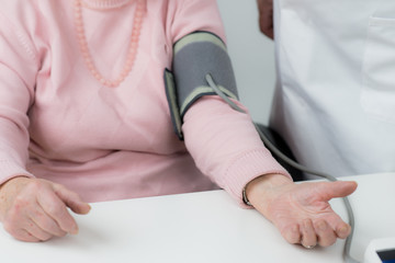 Obraz premium blutdruck messen bei einer alten frau