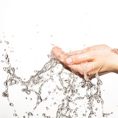 Closeup female hands under the stream of splashing water