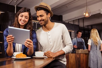 Couple using a tablet in a coffee shop