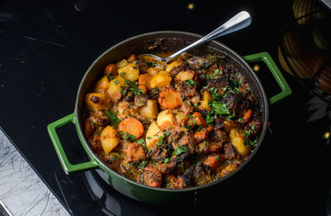Baked potatoes with beef and prunes.