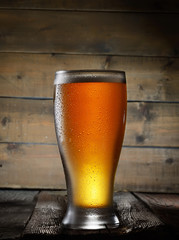 Beer. A glass of beer on a wooden background
