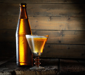 Beer. Beer bottle and glass on a wooden background