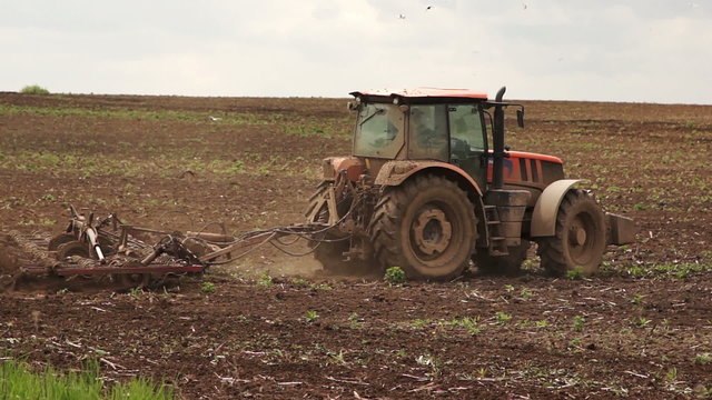Farmer working on the field at the tractor