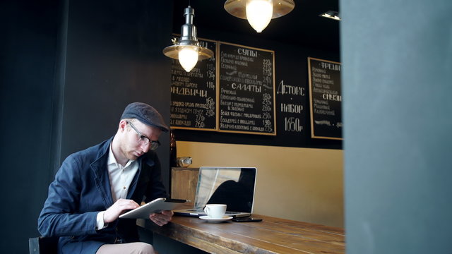 Young man using tablet computer in cafe