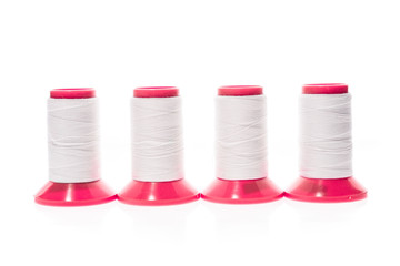 Professional sewing threads on a red industrial roll.