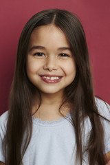 Smiling girl with long hair against red