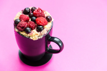 Mug Cake with Berries Prepared in Microwave on Pink Funny Background, Horizontal View, Free Space for Text