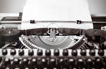 Old typewriter on wooden table. Vintage style tinted photo.