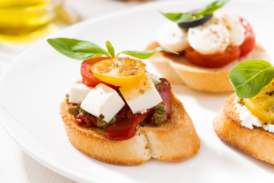 bruschettas with tomatoes and mozzarella on plate, closeup