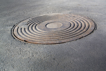 Fototapeta na wymiar Sewer manhole on the city asphalt road