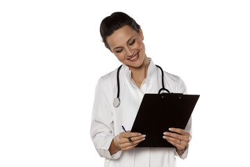 smiling woman doctor in uniform reading her clipboard