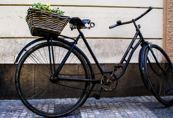 Fototapeta na wymiar Vintage bicycle with a basket parked in the street of Prague.