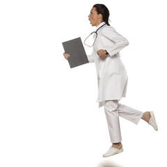 beautiful woman doctor in uniform running with clipboard in her hand