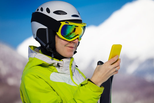 Skier woman look up in smart phone