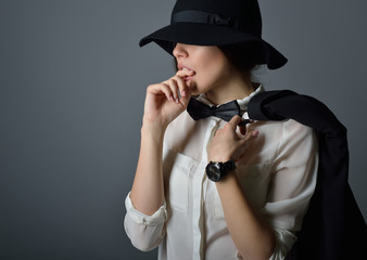 Young beautiful sexy woman in jacket, white shirt, bow-tie and h