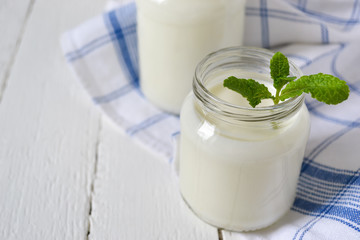 Obraz na płótnie Canvas natural yogurt in glass jar, white background