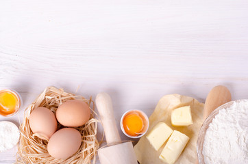 Ingredients for baking croissants - flour, wooden spoon, rolling pin, eggs, egg yolks, butter...