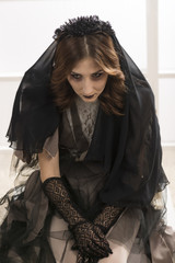 Dead widow in grief. Dark Beautiful Gothic Princess.Halloween party. Young beautiful demonic female
