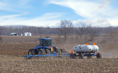 Tractor Pulling Anhydrous Ammonia Tanks Fertilizing a Farm Field