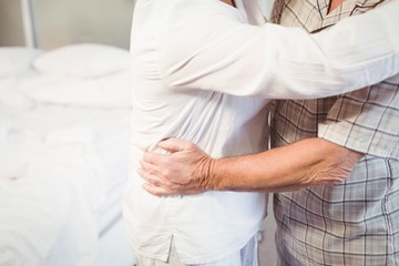 Obraz na płótnie Canvas Midsection of senior man embracing wife