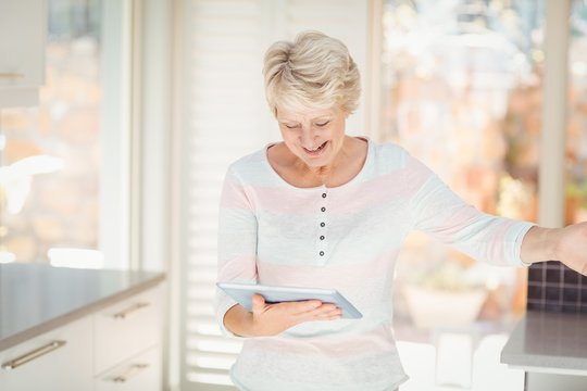 Happy senior woman using digital tablet