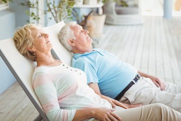 Senior couple relaxing on lounge chair - Powered by Adobe