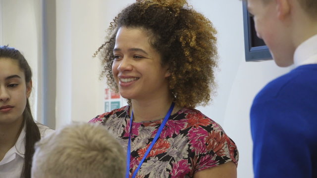 Young teacher talking to her students during a lesson.