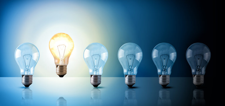 Idea concept with light bulbs sequence on blue background