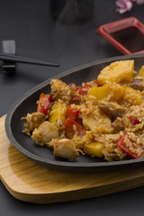 Asian rice with meat and pineapple over black background