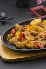 Asian rice with meat and pineapple over black background