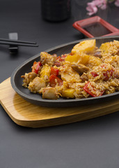 Asian rice with meat and pineapple over black background