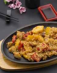 Asian rice with meat and pineapple over black background