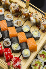 Sushi set with different fish on a wooden plate.