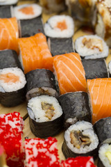 Sushi set with different fish on a wooden plate.
