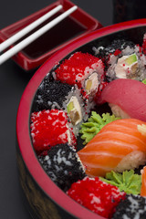 Sushi set with ginger wasabi and chopsticks and soy saue over stone background