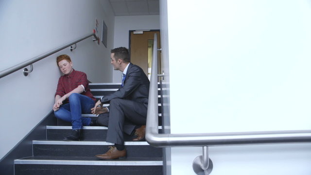 Head teacher of the school talking to a student who has been causing problems in lesson.
