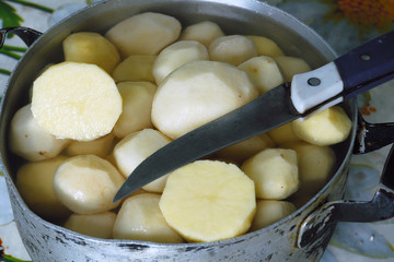 Peeled potatoes in metal pan