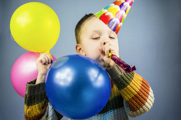 Fototapeta na wymiar boy in a celebratory cap with colored balls