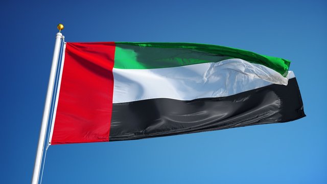 Emirates flag waving in slow motion against clean blue sky, seamlessly looped close up, isolated on alpha channel with black and white luminance matte, perfect for film, news, digital composition