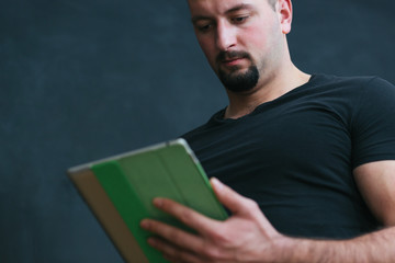 Portrait of a handsome  young man  holding a tablet in his hands