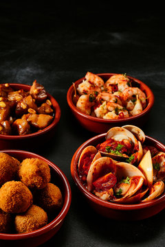 Bowls of tapas on black background