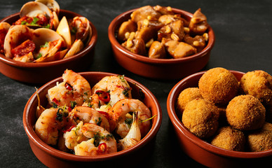 Four bowls of Spanish appetizers - obrazy, fototapety, plakaty