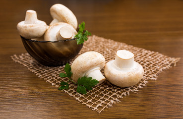 Mushrooms champignons on a wooden table